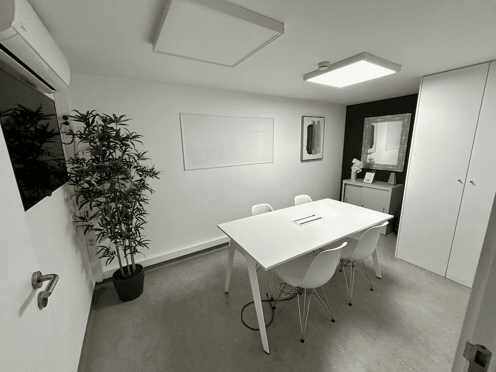 Sala Lisboa no Cowork Malvarosa, mesa de reunião para quatro pessoas, televisor e quadro branco